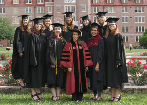 Dr. Adriane Pereira, centered in red Doctoral robes, among her graduating students.