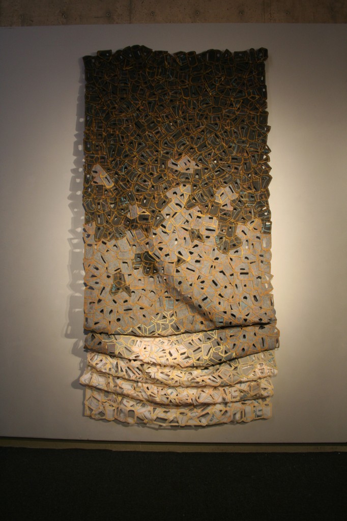 Textile work in a variety of colors up on a gallery wall