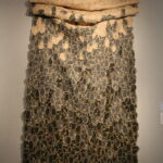 Textile work in a variety of colors up on a gallery wall