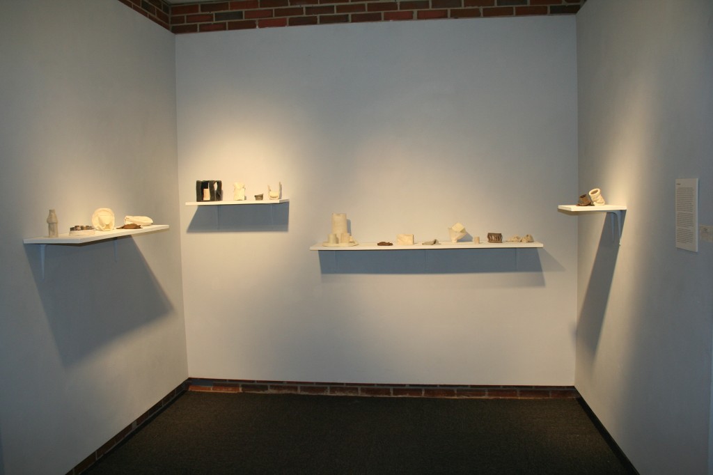 Display of hand made shapes on a shelf in a gallery space