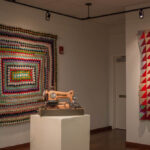 Angled shot of sewing machine in-between two quilts
