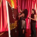 3 women around painting