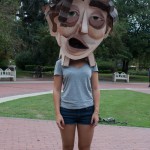 Straight on photo of female student with cardboard head