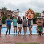 Students pose with cardboard heads in front of fountain