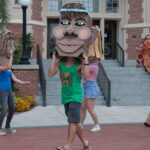 Male student with cardboard head dancing