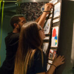 Side shot of two students hanging their project