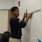 Side shot of a student drawing and measuring