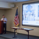 Angled shot of man giving presentation with slide