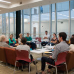 Angled shot of a group of graduate students listening to Jean Massing