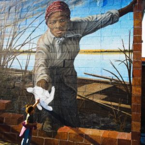 A photo captured by Tracy Lynndee in Cambridge, Maryland of her 3-year-old granddaughter, "Lovie" Hope Duncan touching the hand of abolitionist Harriet Tubman has become a viral sensation on the internet. (Photo: Tracy Lynndee/Special to the Democrat)