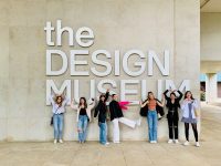 A group of students stands in front of a sign reading "the design museum."
