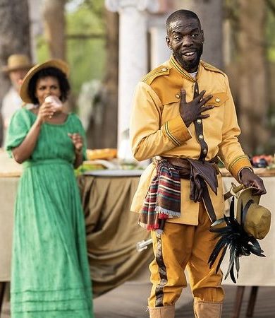 Two actors in brightly colored costumes perform a Shakespearian play.