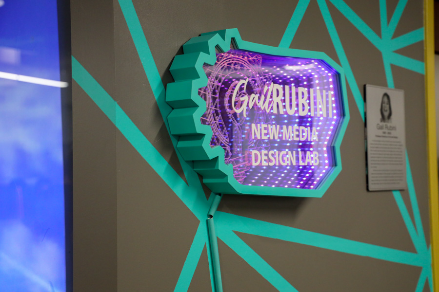 A bright blue and purple sign reads "Gail Rubini New Media Design Lab"