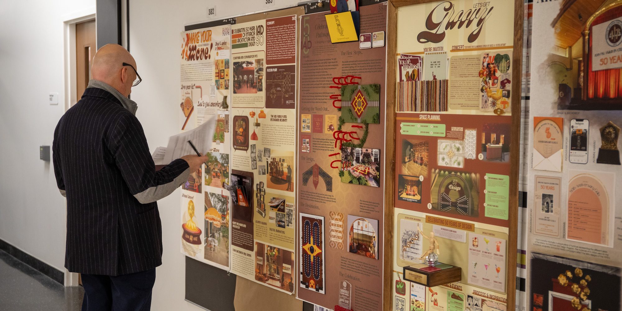 A man examines posters on a bulletin board