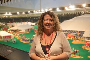 A woman poses in front of a miniature circus