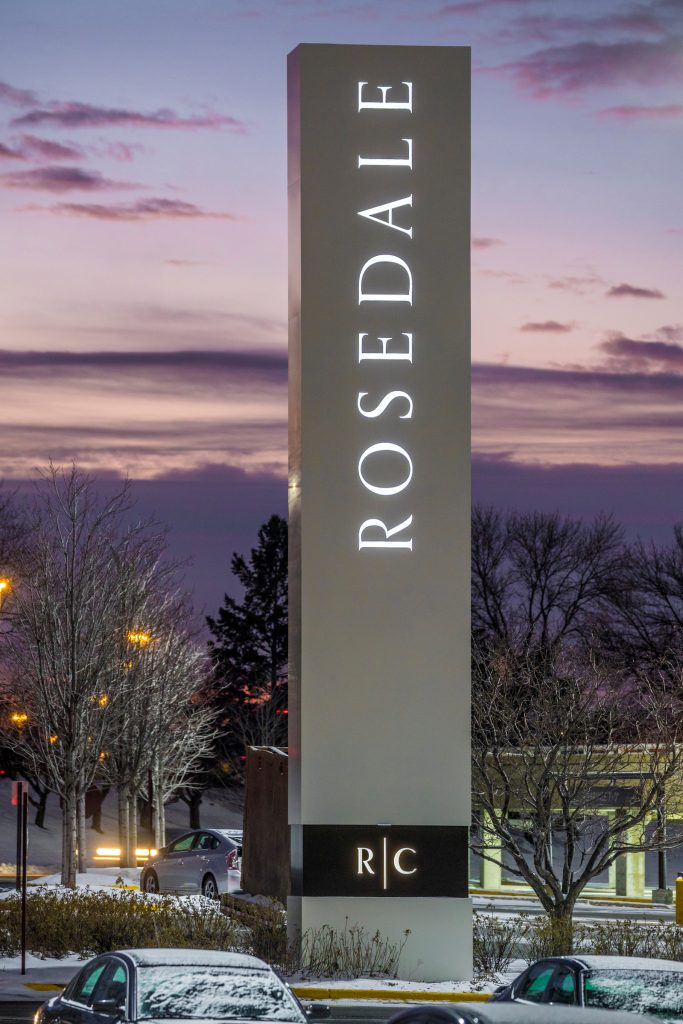 a large sign that says rosedale in front of a parking lot