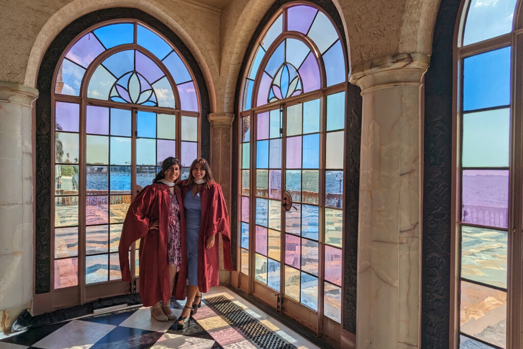 two women standing in front of stained glass windows