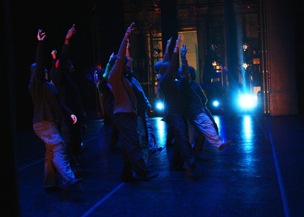Students perform on a dark stage