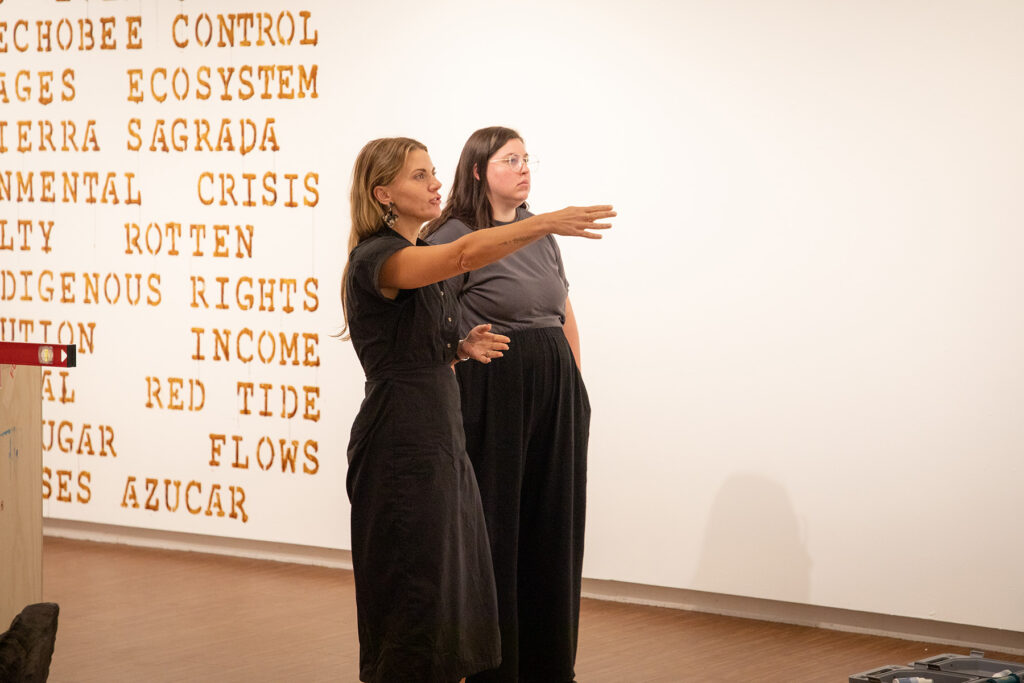 there are two women that are standing in front of a white wall