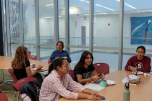 People sitting at desks in an atrium in an academic setting