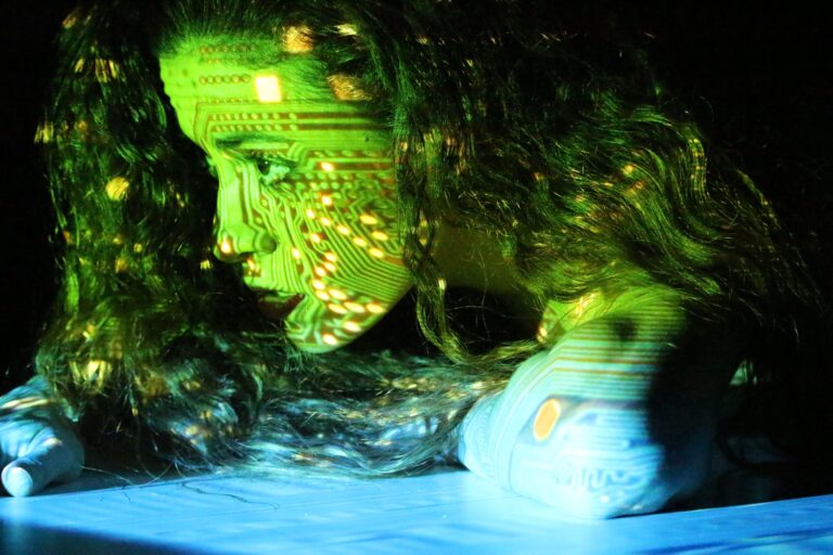 a light green and blue digital chip picture is projected on a woman's face
