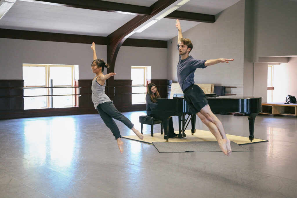 two person dancing to music played on piano behind on stage practice