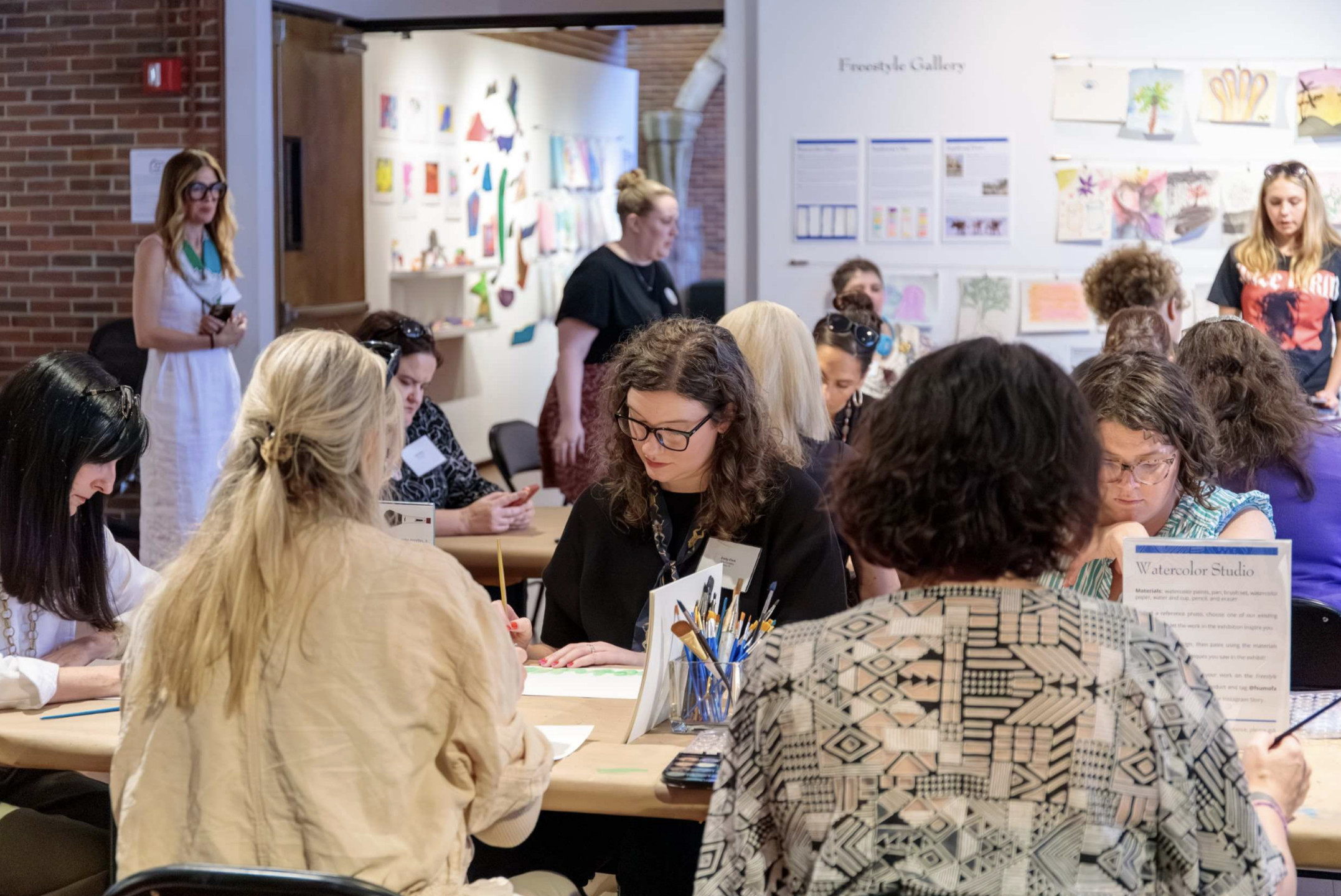 A group seated at various tables making watercolor paintings.