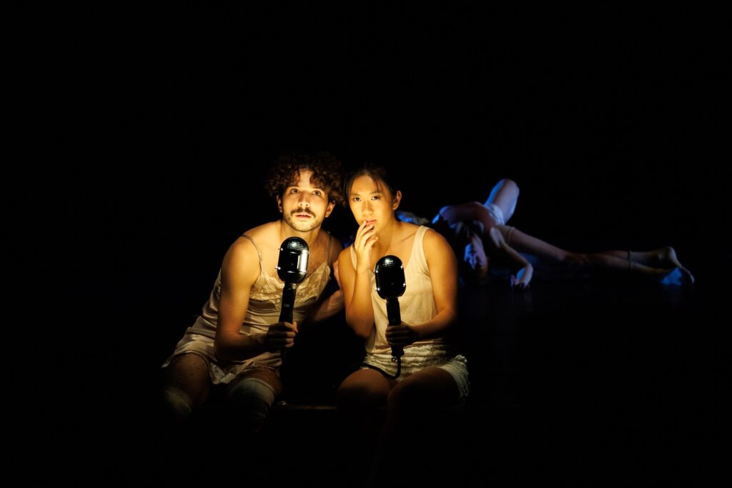 A photo of two individuals lit brightly from the front