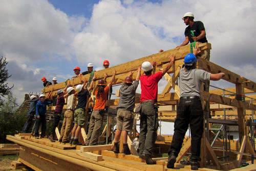 Students and professional timber-framers working together during the Gwozdziec synagogue reconstruction in Sanok, Poland. 