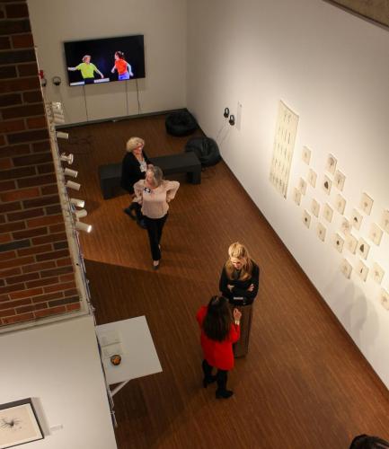 An overhead shot of people wandering in a museum gallery