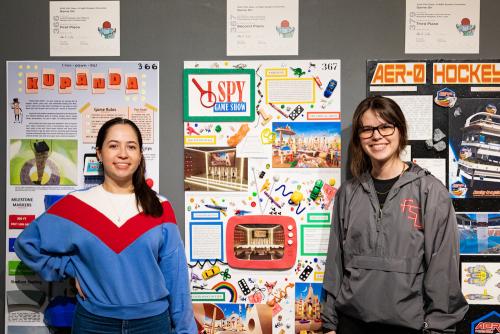Students Ciara Iglesias and Camila Ferro pose with their second-place winning charrette project, which drew inspiration from the "I Spy" children's book series. (Ivan Peñafiel)